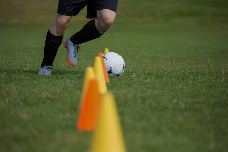 Soccer player dribbling through cones